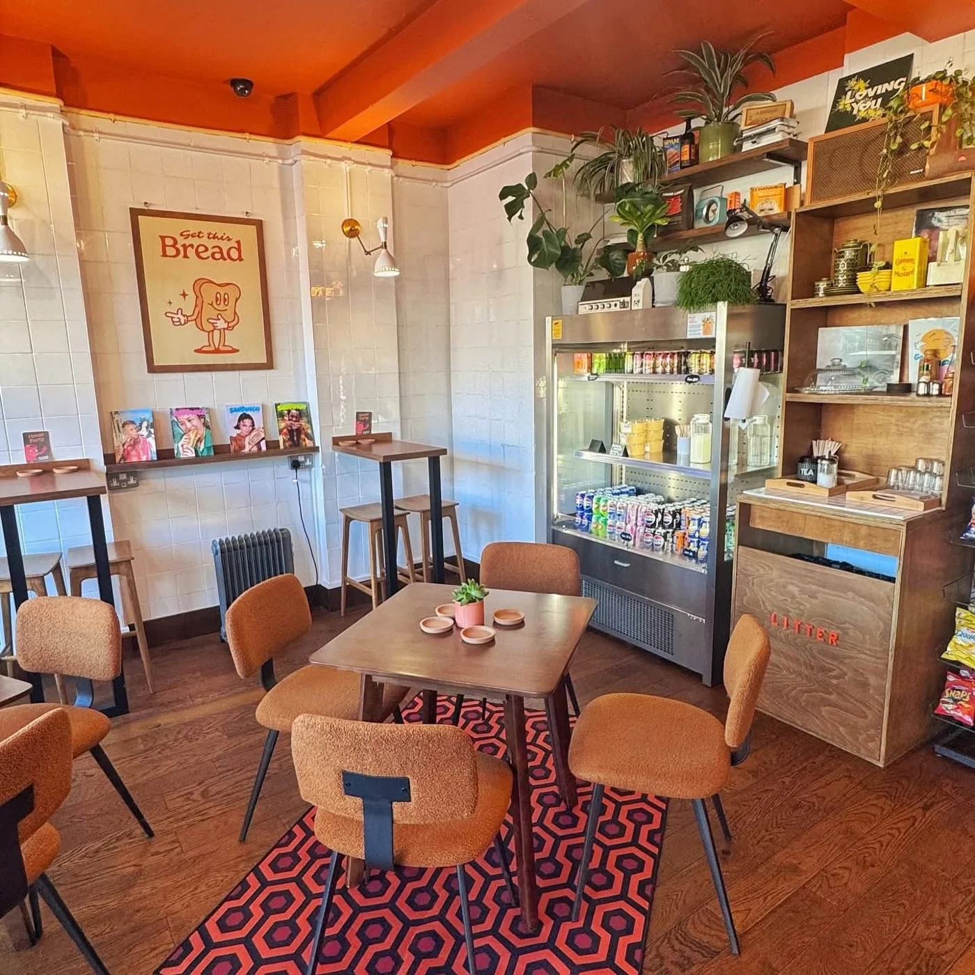 Inside Sabins: orange ceiling, brown upholstered seating and café tiles